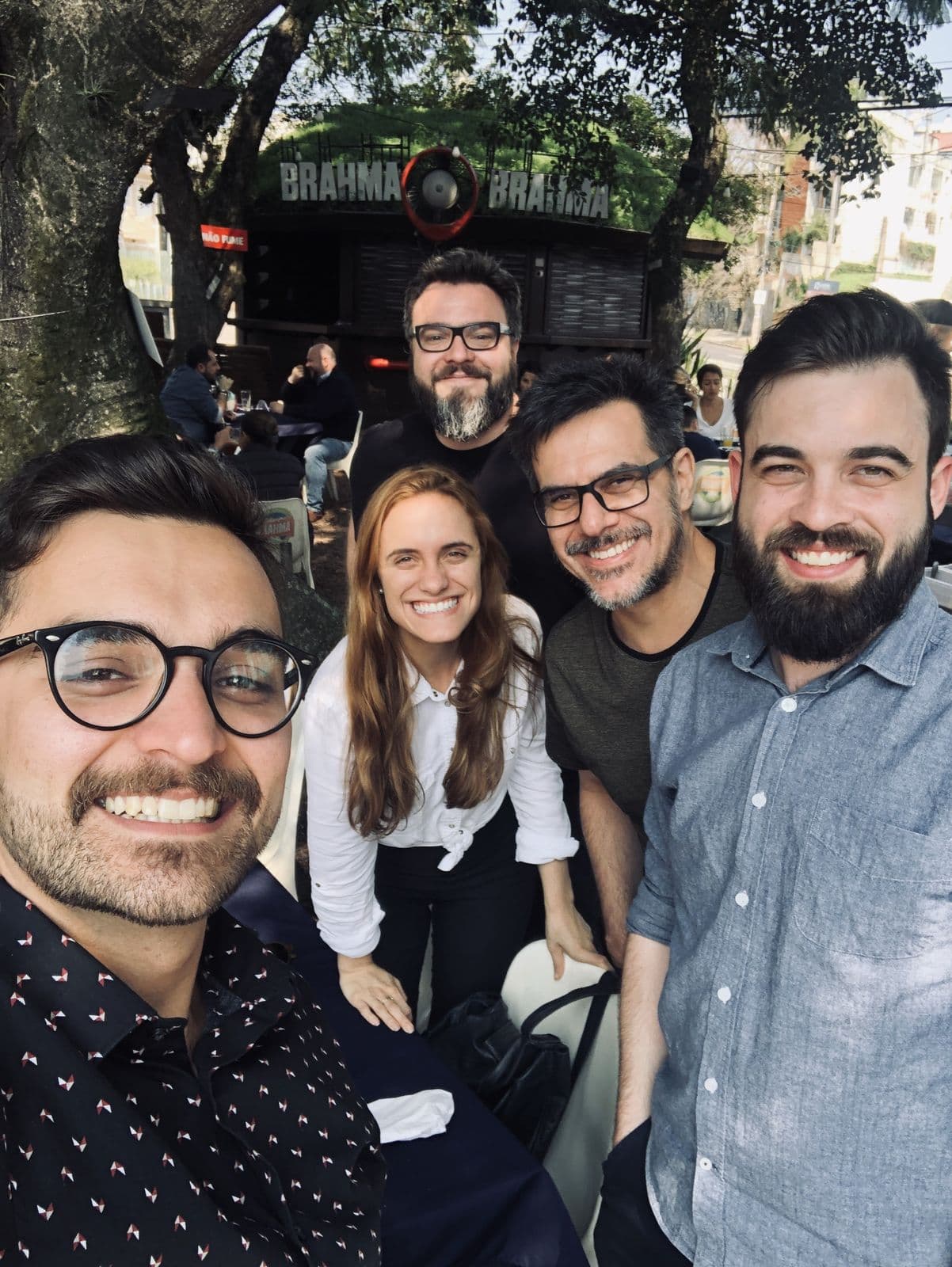 Selfie of five smiling partners at an outdoor table