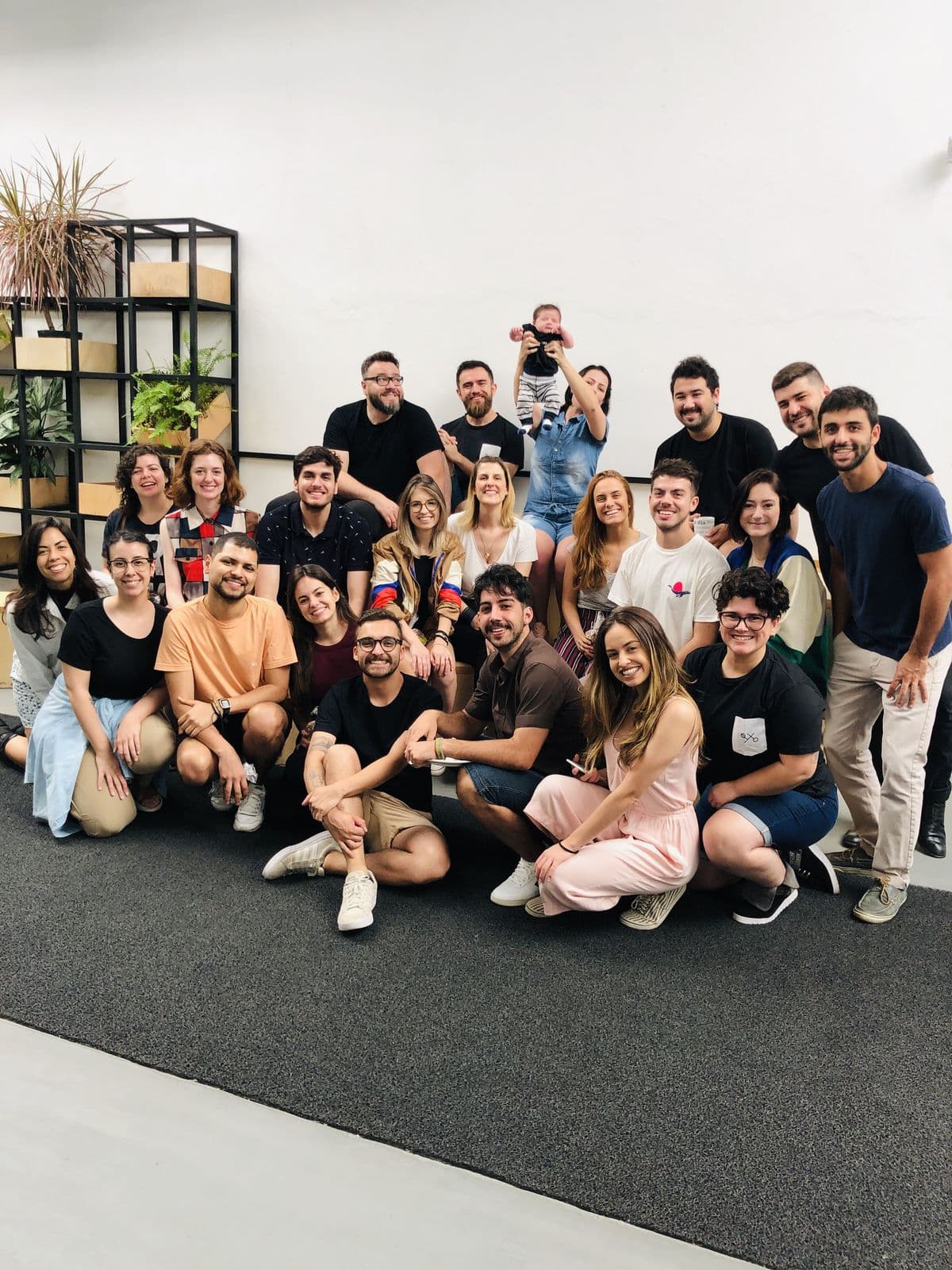 Team group photo, about thirty people in a bright studio