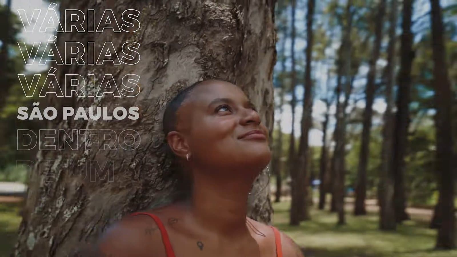 Una mujer apoyada en un árbol mira hacia arriba; al lado, las palabras “varias São Paulos dentro de una” repetidas