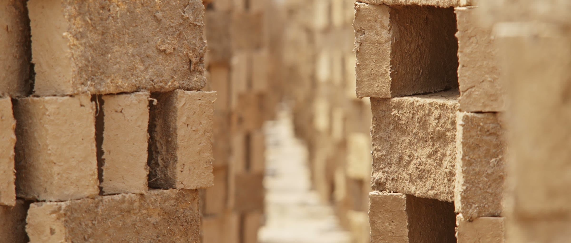 A corridor between stacks of bricks