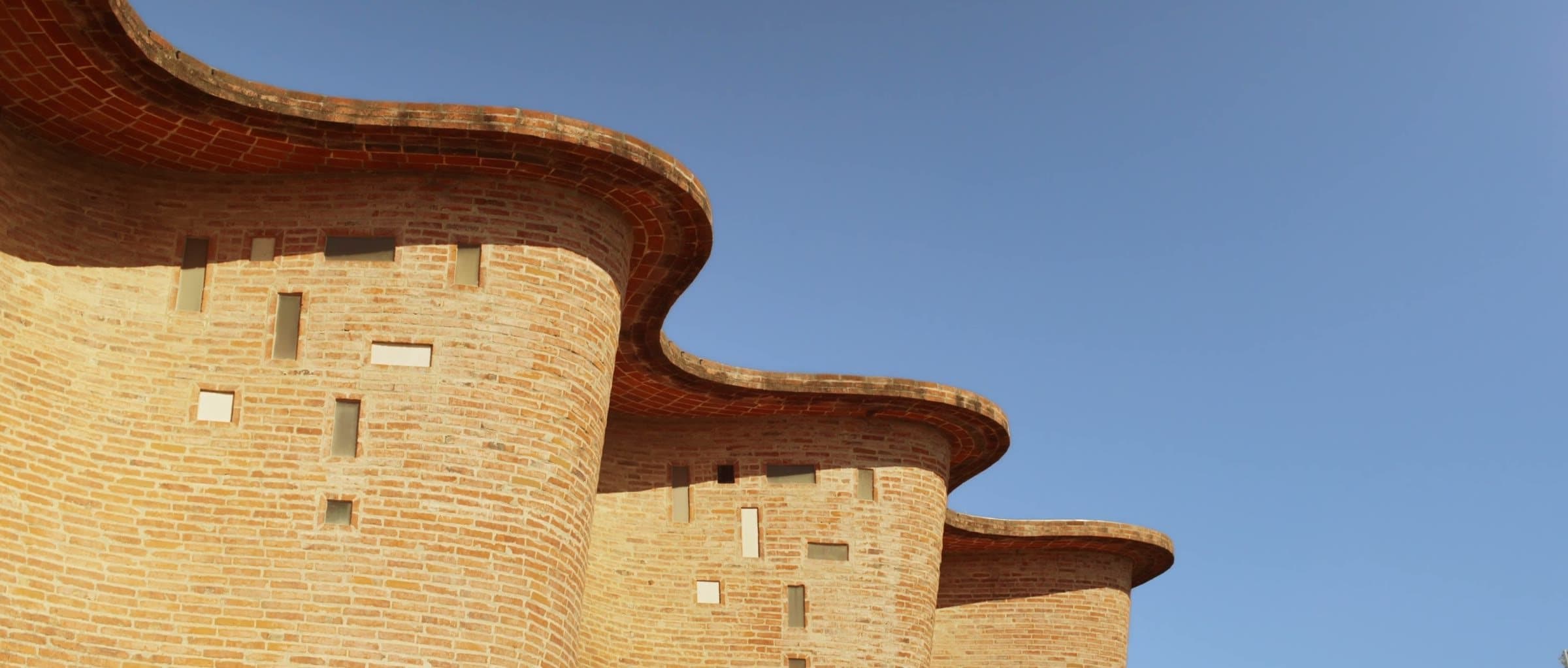 A curved brick façade against the sky