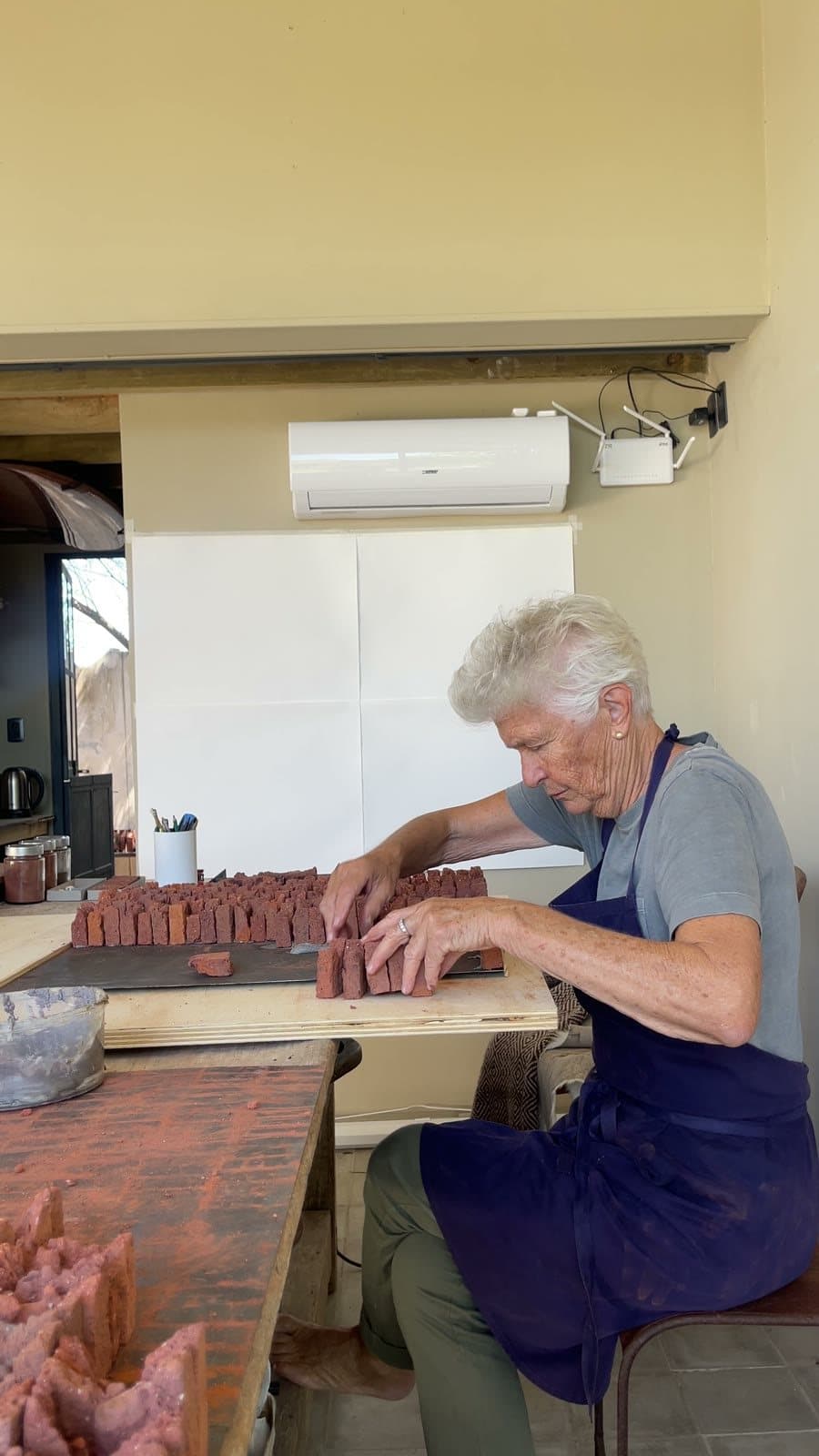 Heloísa Crocco seated, assembling a work