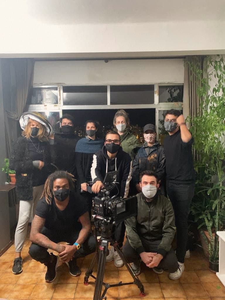 The crew gathered around the camera, in masks