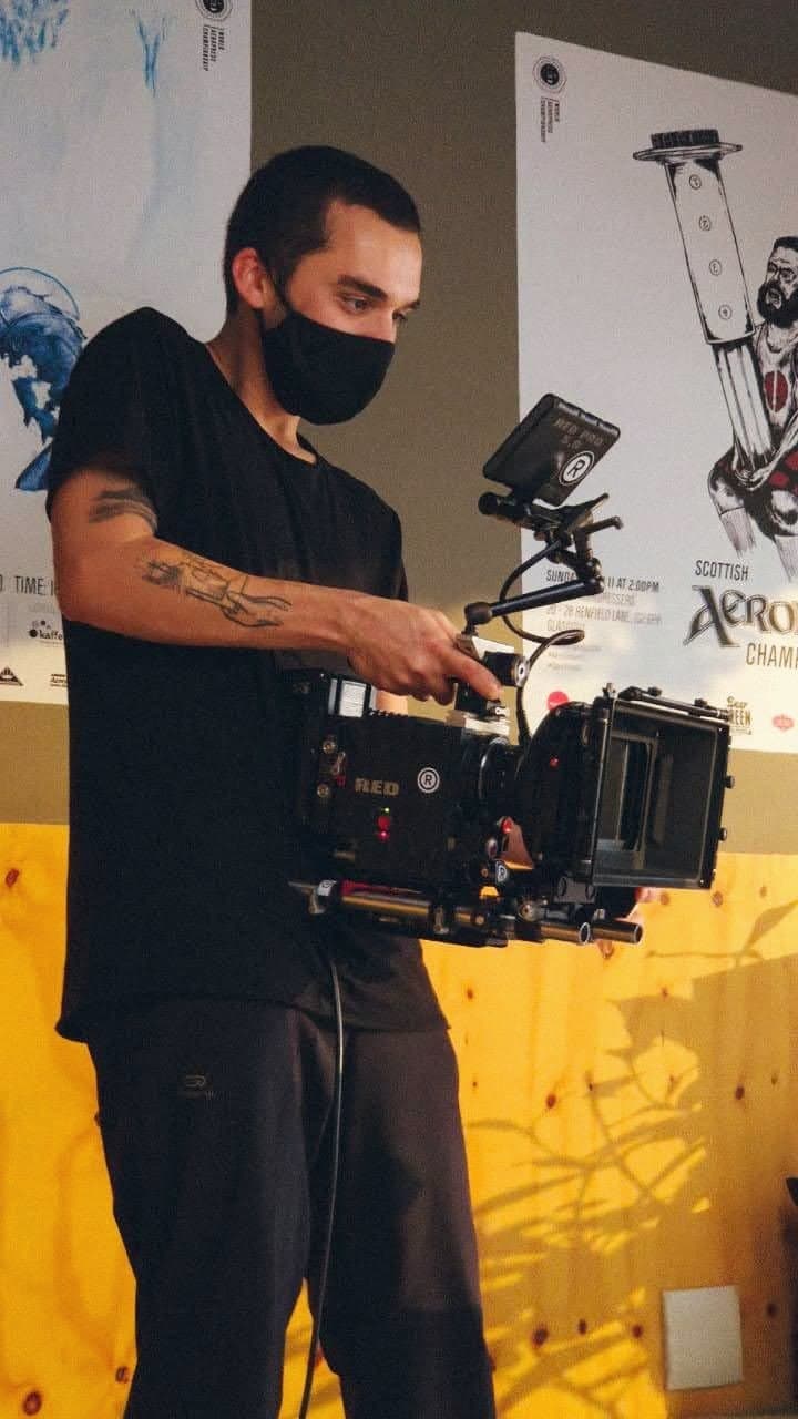 Nando in a mask with the camera in hand, on set