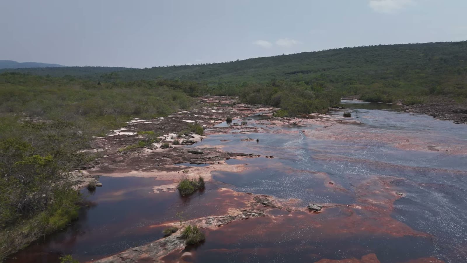 Aerial view of Rio Espalhado, with reddish water running between the rocks and the cerrado vegetation