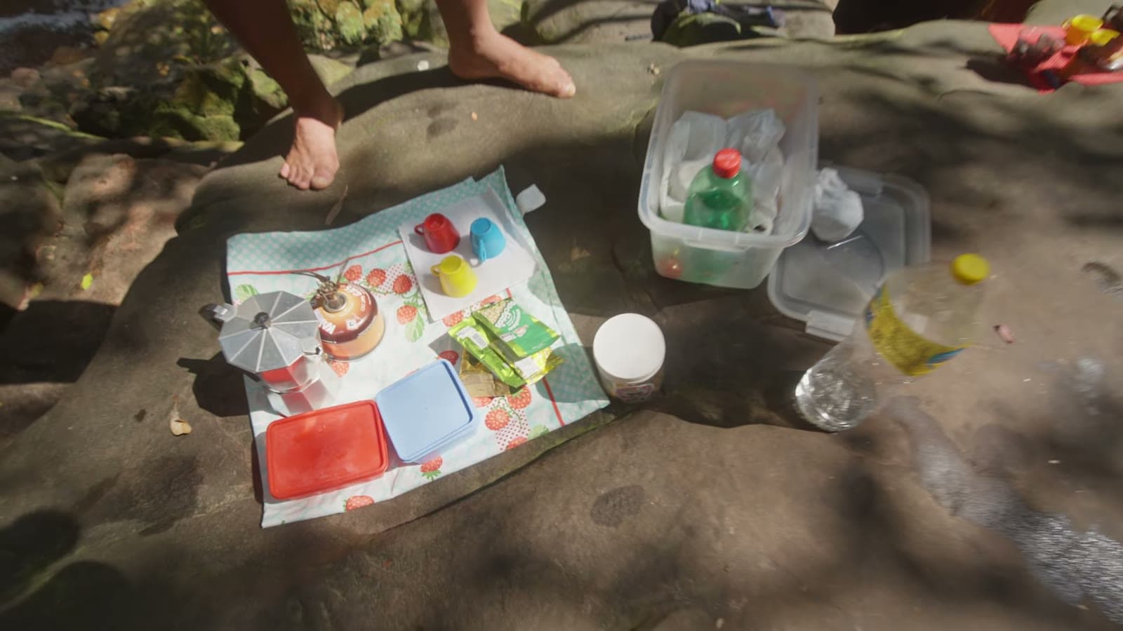 Towel spread on the rock with a thermos, cups and snacks from the coffee the guide prepared