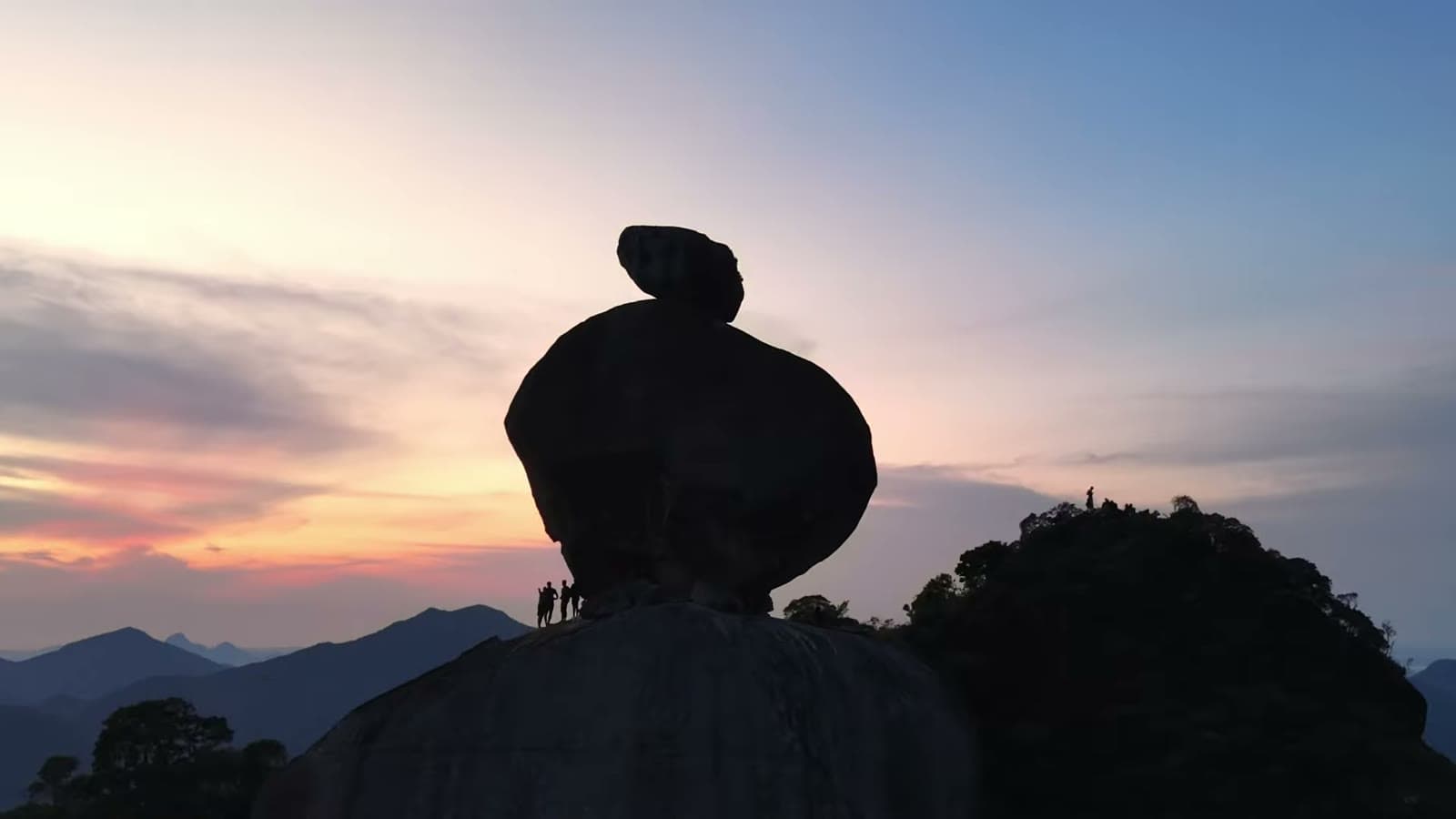 Silhouette of Peito do Pombo against the pink dawn sky, above the mountains