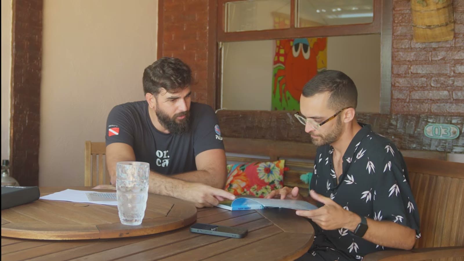 Nicholas and Nando sitting at a wooden table, studying the course's theory material