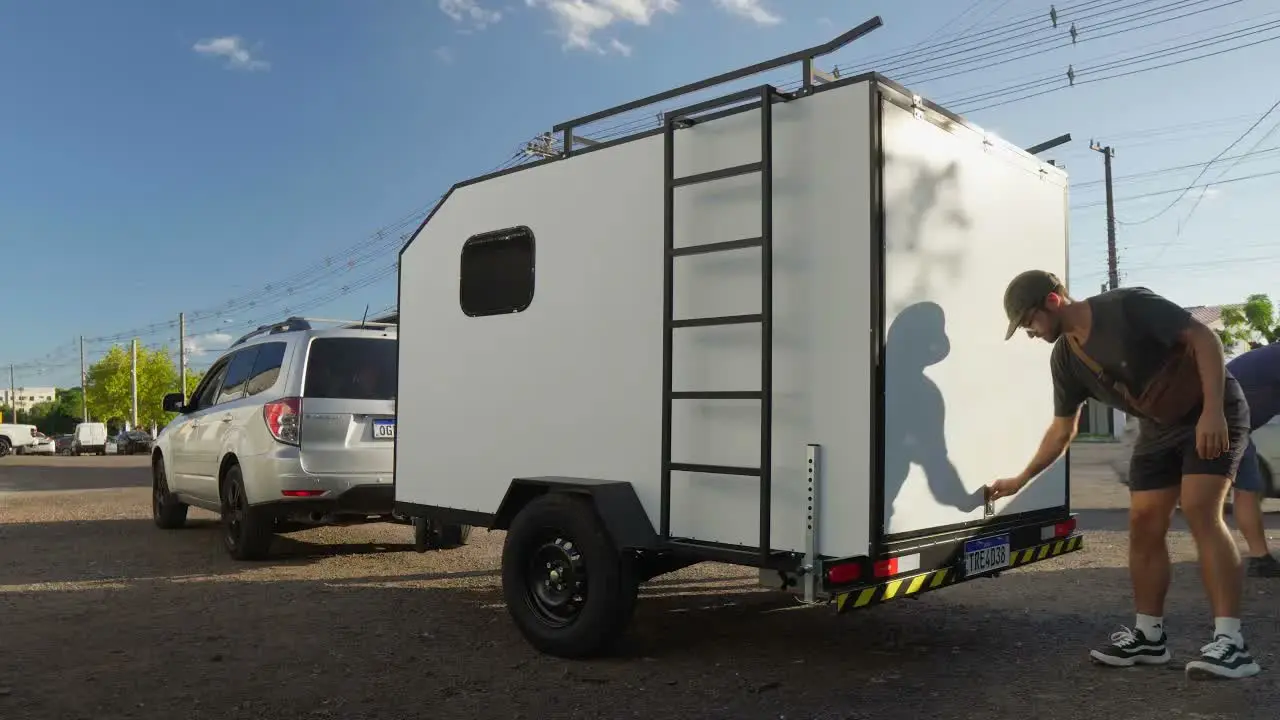 Nando ao lado do mini trailer branco engatado no Subaru Forester, capa do post